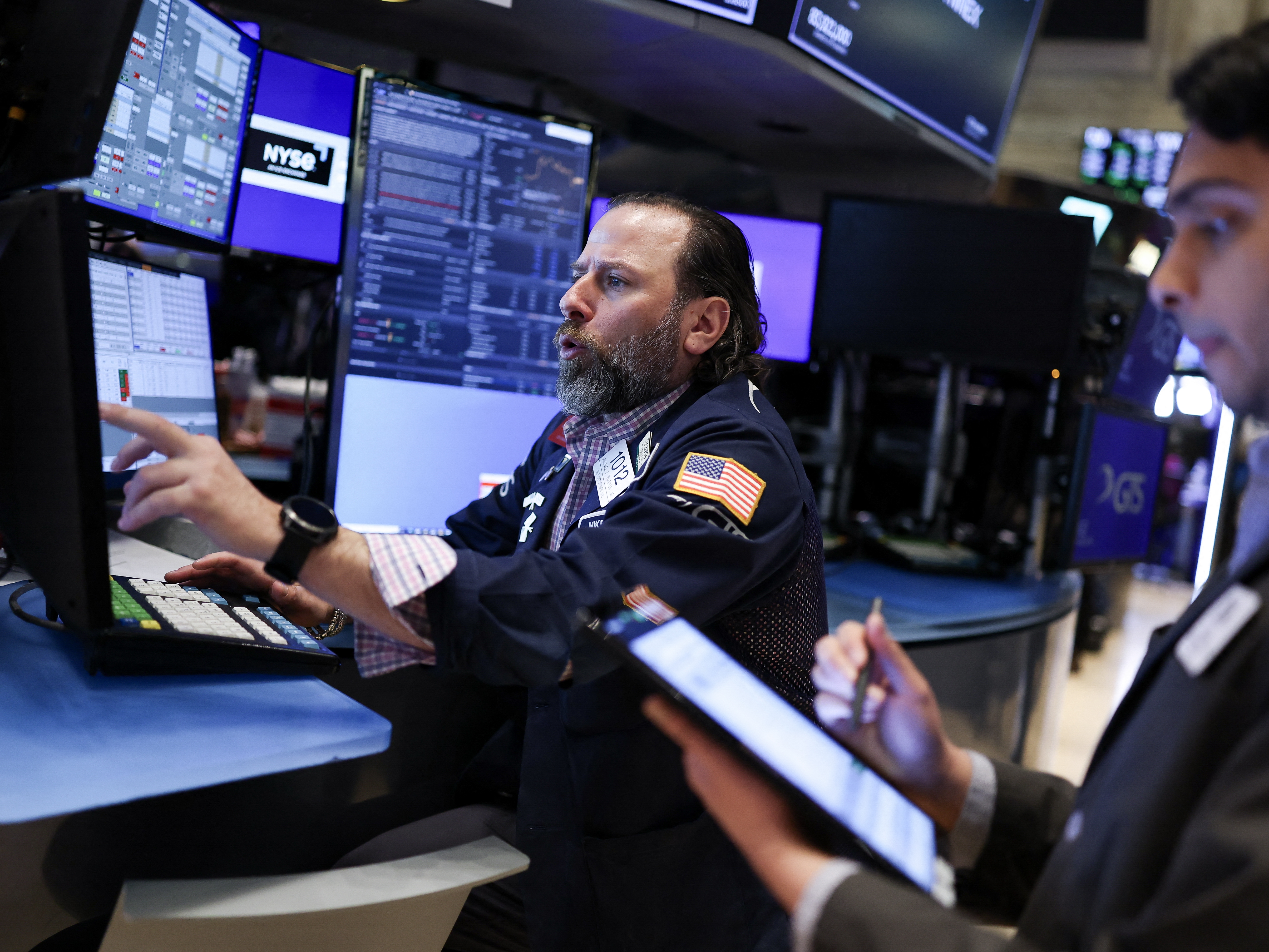caption: Traders work on the floor of the New York Stock Exchange at the opening bell on Thursday in New York City. Stocks resumed declines after gaining spectacularly a day earlier.