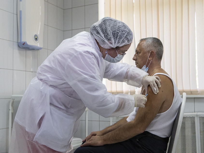 caption: A Moscow health care worker administers a shot of Russia's Sputnik V coronavirus vaccine during clinical trials in September. President Vladimir Putin ordered the nation's health authorities to begin mass vaccinations next week.