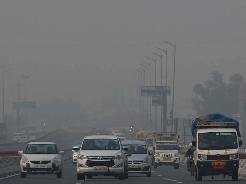 caption: Commuters drive along a road amid heavy smog conditions in New Delhi last week.