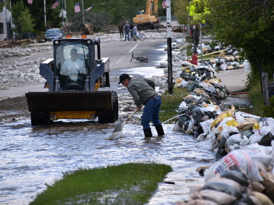 caption: Residents of Red Lodge, Mont., are seen clearing mud, water and debris from the small city's main street after flood waters coursed through a residential area with hundreds of homes.