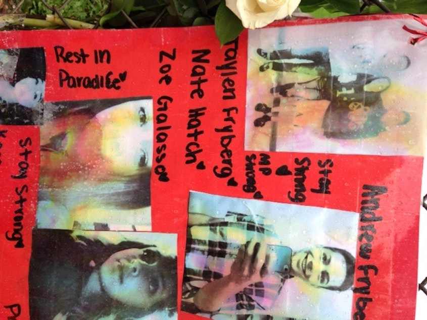 caption: Photos of the students shot at Marysville-Pilchuck High School are seen in a memorial last year.