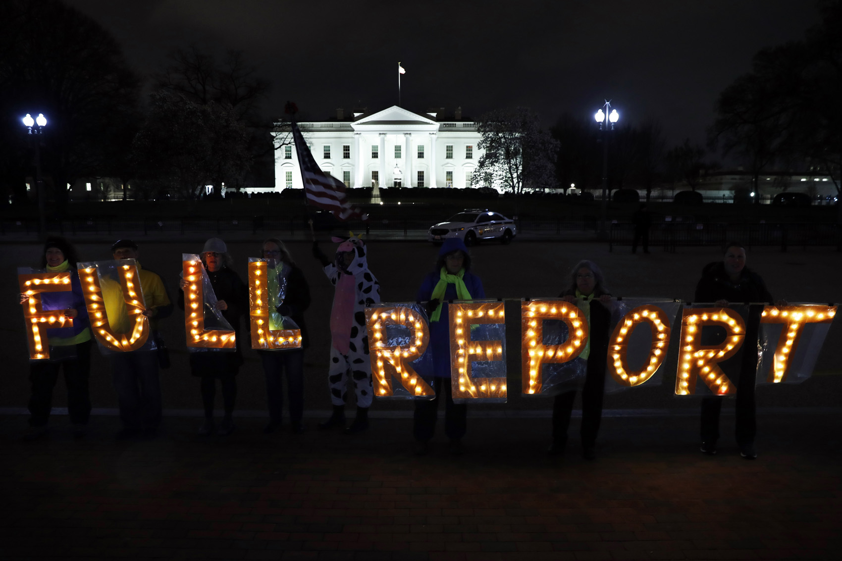 caption: Members of the protest group Herndon Reston Indivisible and Kremlin Annex hold signs saying "Full Report," outside the White House in Washington, Monday, March 25, 2019. (Jacquelyn Martin/AP)