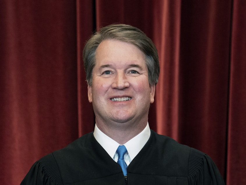 caption: Associate Justice Brett Kavanaugh stands during a group photo at the Supreme Court in Washington last year.