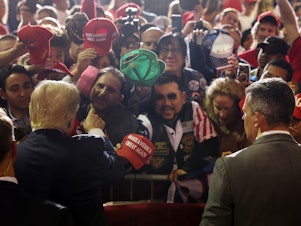 caption: Former President Donald Trump greets supporters at a campaign rally on April 27, 2023 in Manchester, N.H.