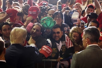 caption: Former President Donald Trump greets supporters at a campaign rally on April 27, 2023 in Manchester, N.H.
