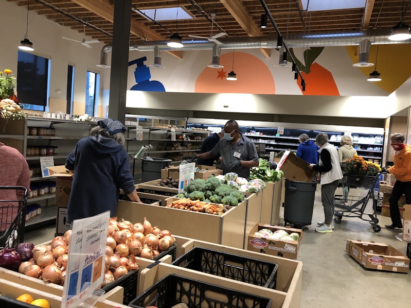 caption: Volunteers stock bins with fresh produce at Ballard Food Bank. Increasingly, food banks are adopting a grocery-style model of service.