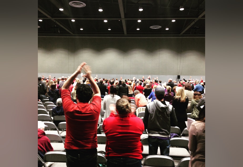 caption: Tacoma activists stand in opposition to a proposed methanol plant at a public meeting in 2016.