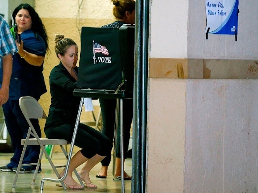 caption: South Florida voters cast their vote late in the day at a busy polling center in Miami on Nov. 6, 2018.