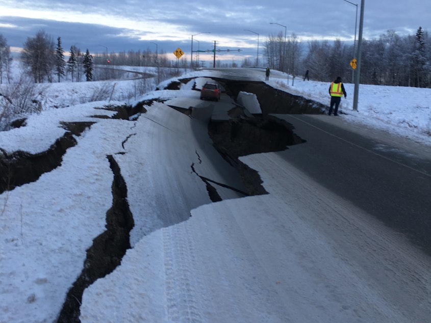 caption: After an earthquake on Friday, a car is trapped in a crumbled section of an off-ramp from Minnesota Drive, a major road in Anchorage, Alaska.