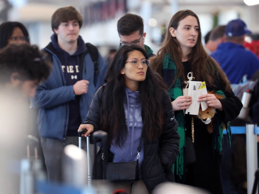 caption: Travelers arrive for flights at the  O'Hare International Airport, in Chicago, on December 16.