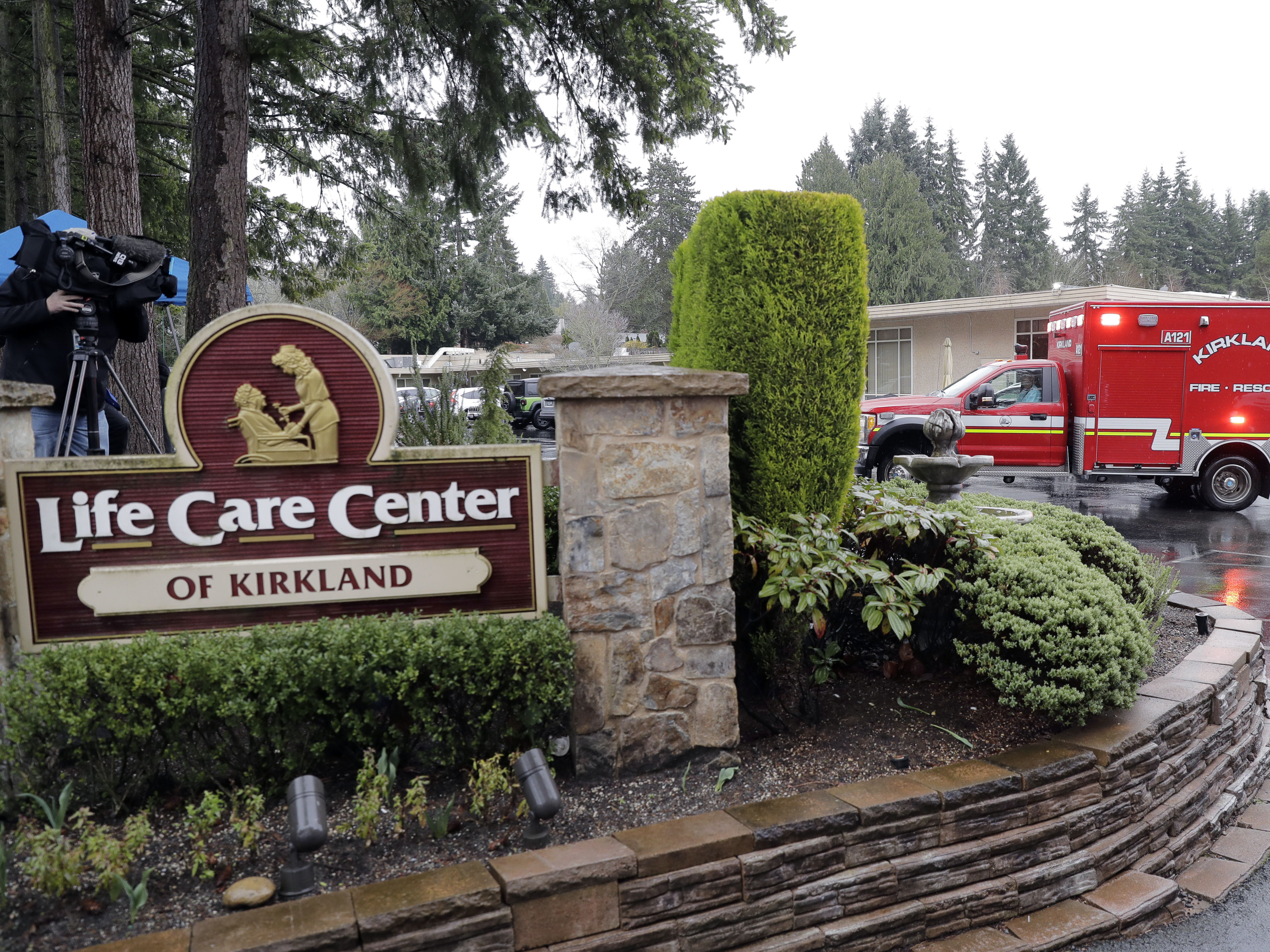 caption: An ambulance backs into a parking lot on Friday at the Life Care Center in Kirkland, Wash., which has become the epicenter of the coronavirus outbreak in Washington state.