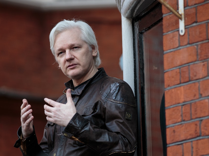 caption: Julian Assange speaks to the media from the balcony of the Ecuadorian Embassy in London last year.