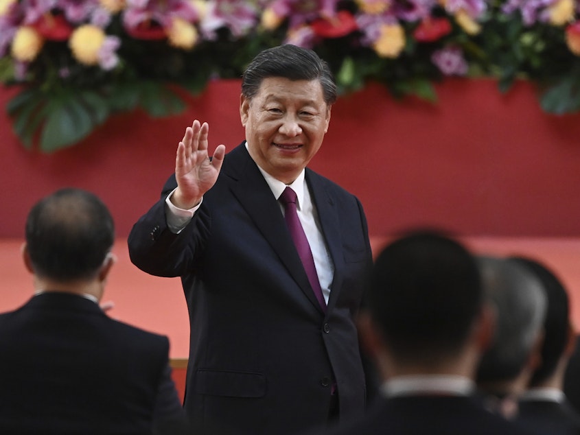 caption: China's President Xi Jinping waves following his speech after a ceremony to inaugurate the city's new government in Hong Kong Friday, July 1, 2022, on the 25th anniversary of the city's handover from Britain to China.