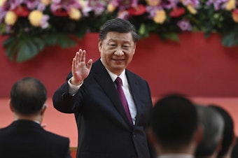 caption: China's President Xi Jinping waves following his speech after a ceremony to inaugurate the city's new government in Hong Kong Friday, July 1, 2022, on the 25th anniversary of the city's handover from Britain to China.