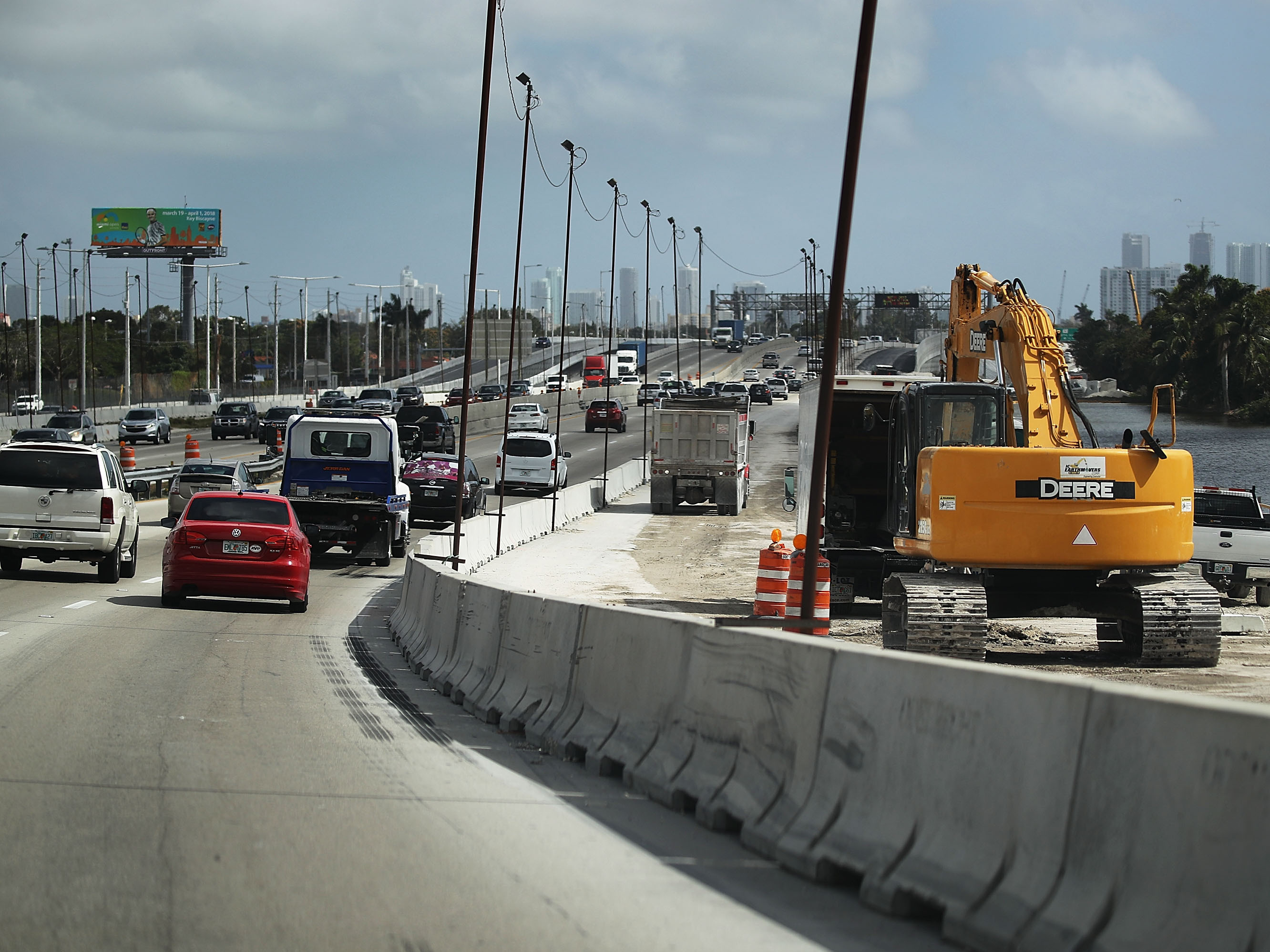 caption: Construction workers build along State Road 836 in 2018 in Miami. HB 1191 would compel the Florida Transportation Department to study using phosphogypsum in paving projects.
