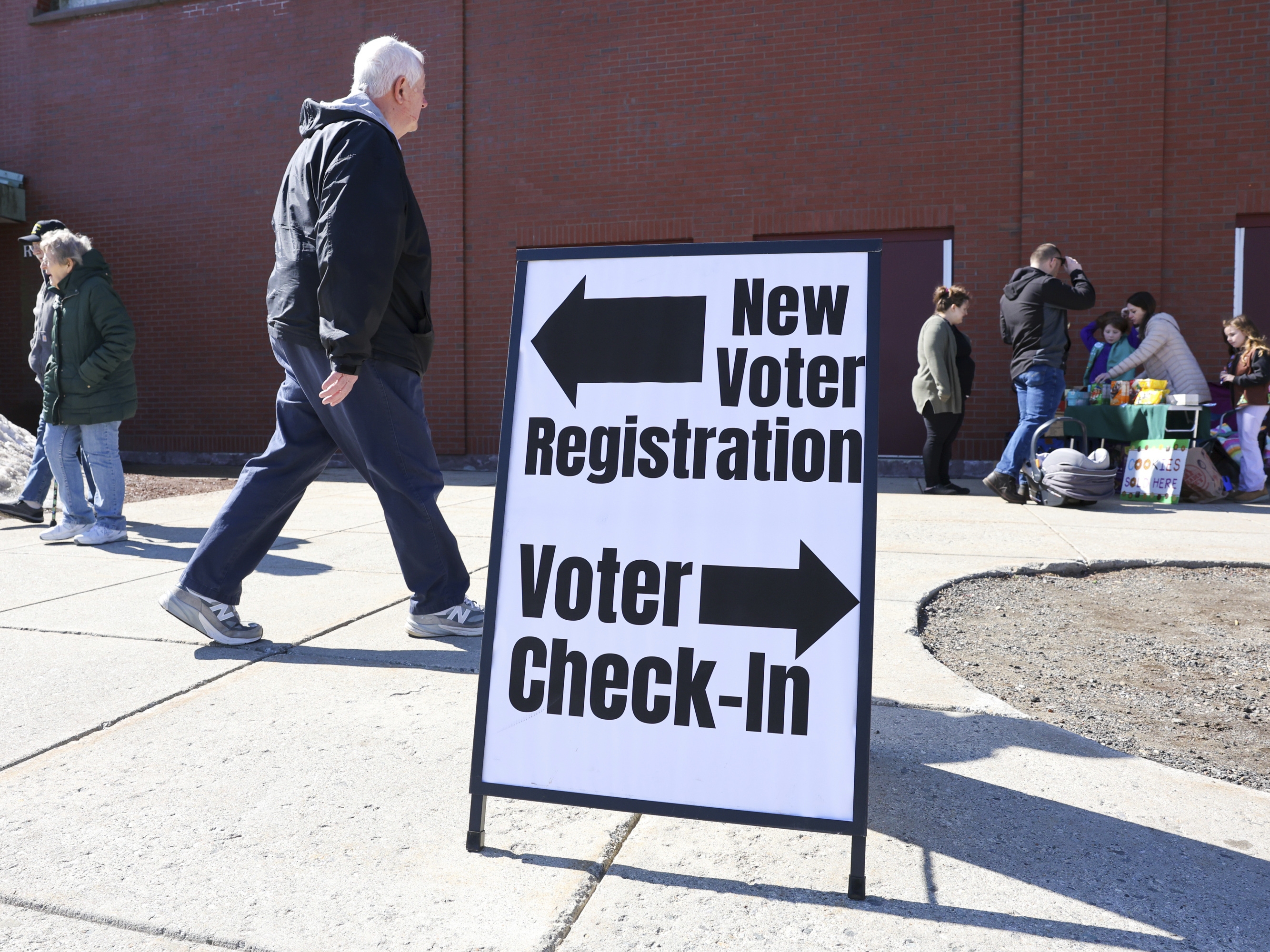 caption: A sign for new voter registration is seen outside a polling location in Derry, N.H., on March 11.