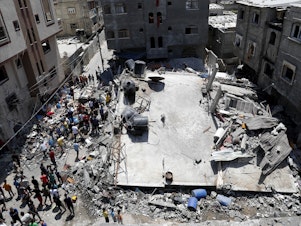 caption: People gather near the rubble of a residential building hit by Israeli airstrikes Thursday in Beit Lahiya, Gaza Strip.