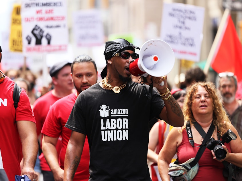 caption: Amazon Labor Union President Chris Smalls leads a pro-union march in New York City in 2022. Workers at an Amazon warehouse on Staten Island voted to unionize that year, but they've since struggled to negotiate a contract with the company. 