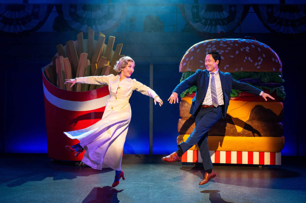 caption:  Grace Yoo (Hillary Clinton) and Daniel May (Xue Xing) in "Soft Power" at Signature Theatre. (Courtesy of Signature Theatre, photo by Daniel Rader)
