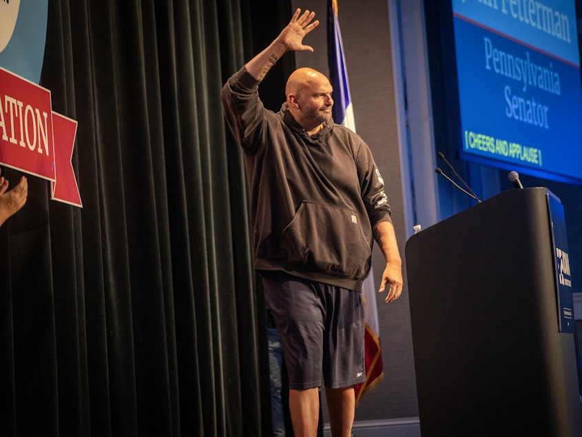 caption: Pennsylvania Sen. John Fetterman walks onto stage in his trademark Carhart hoodie and basketball shorts Saturday night at Prairie Meadows Casino in Altoona, Iowa. Fetterman was the featured speaker at the Iowa Democratic Party's Liberty and Justice Celebration on Nov. 4.