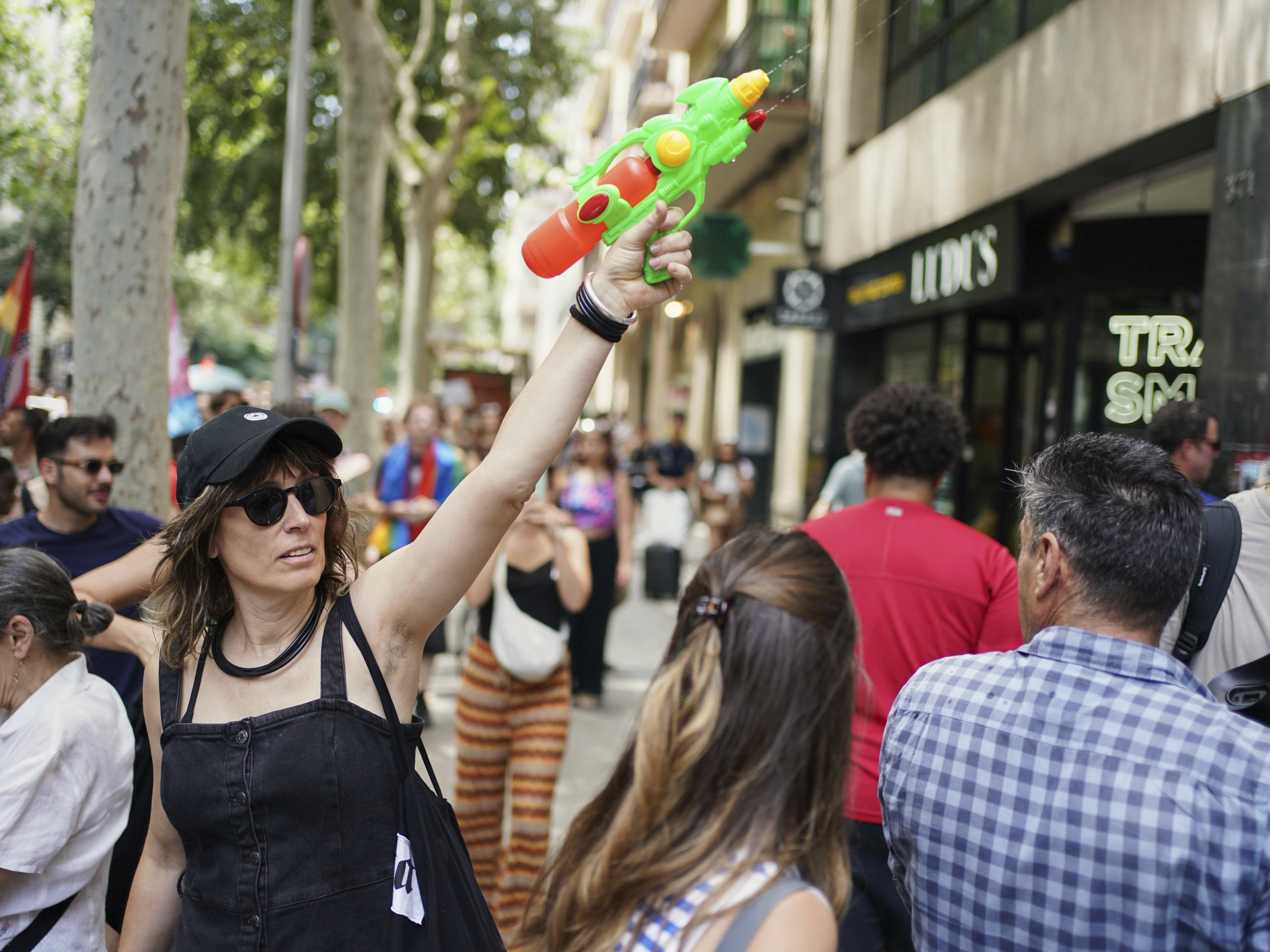 caption: A protester with a water gun takes part in a protest against overtourism in Barcelona, Spain on Sunday.