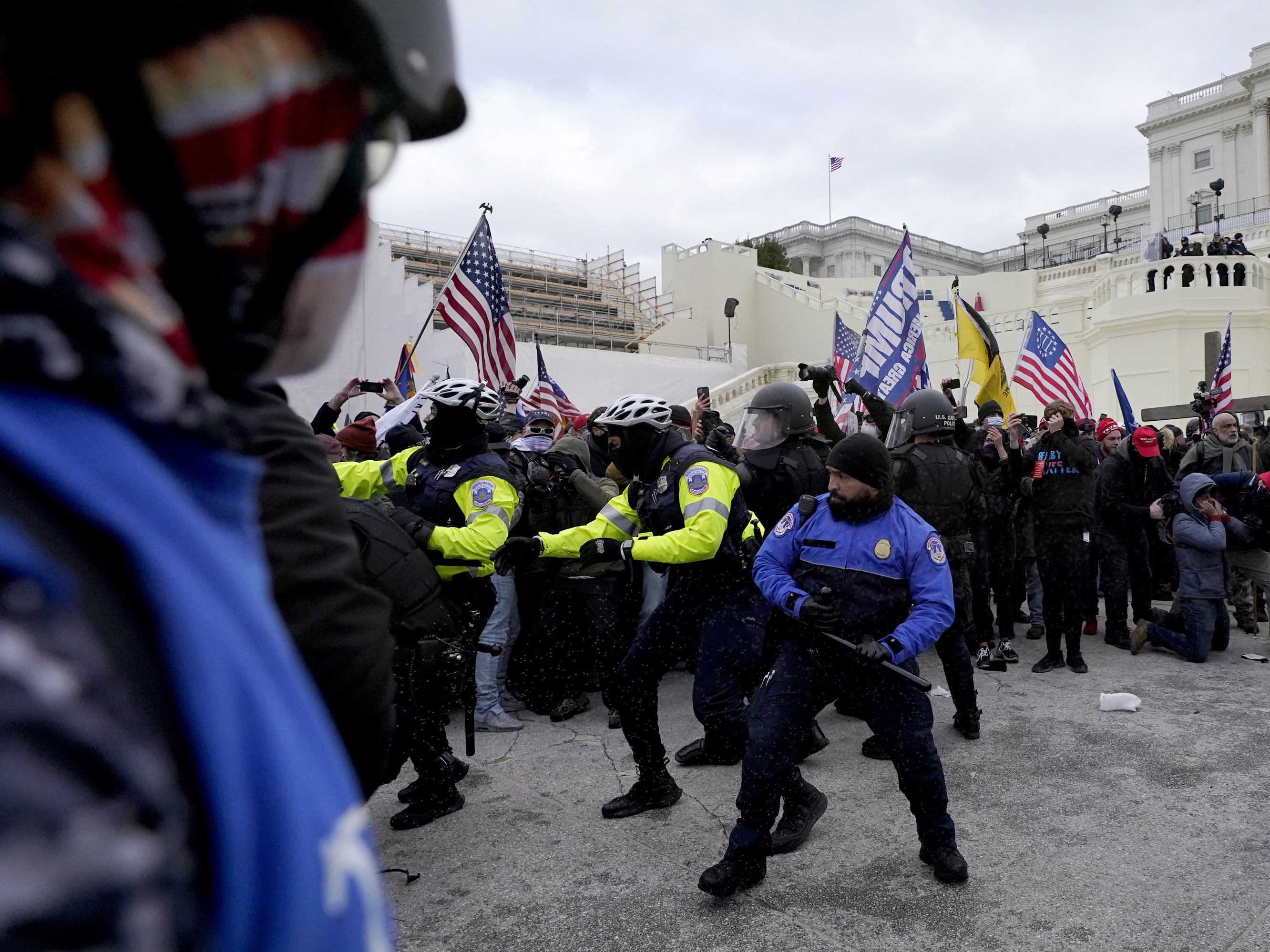 caption: Police officers try to push back President Donald Trump supporters trying to break through a police barrier, Jan. 6 at the Capitol in Washington. Two U.S. Capitol police officers have sued Trump for allegedly inciting the mob that attacked them that day.