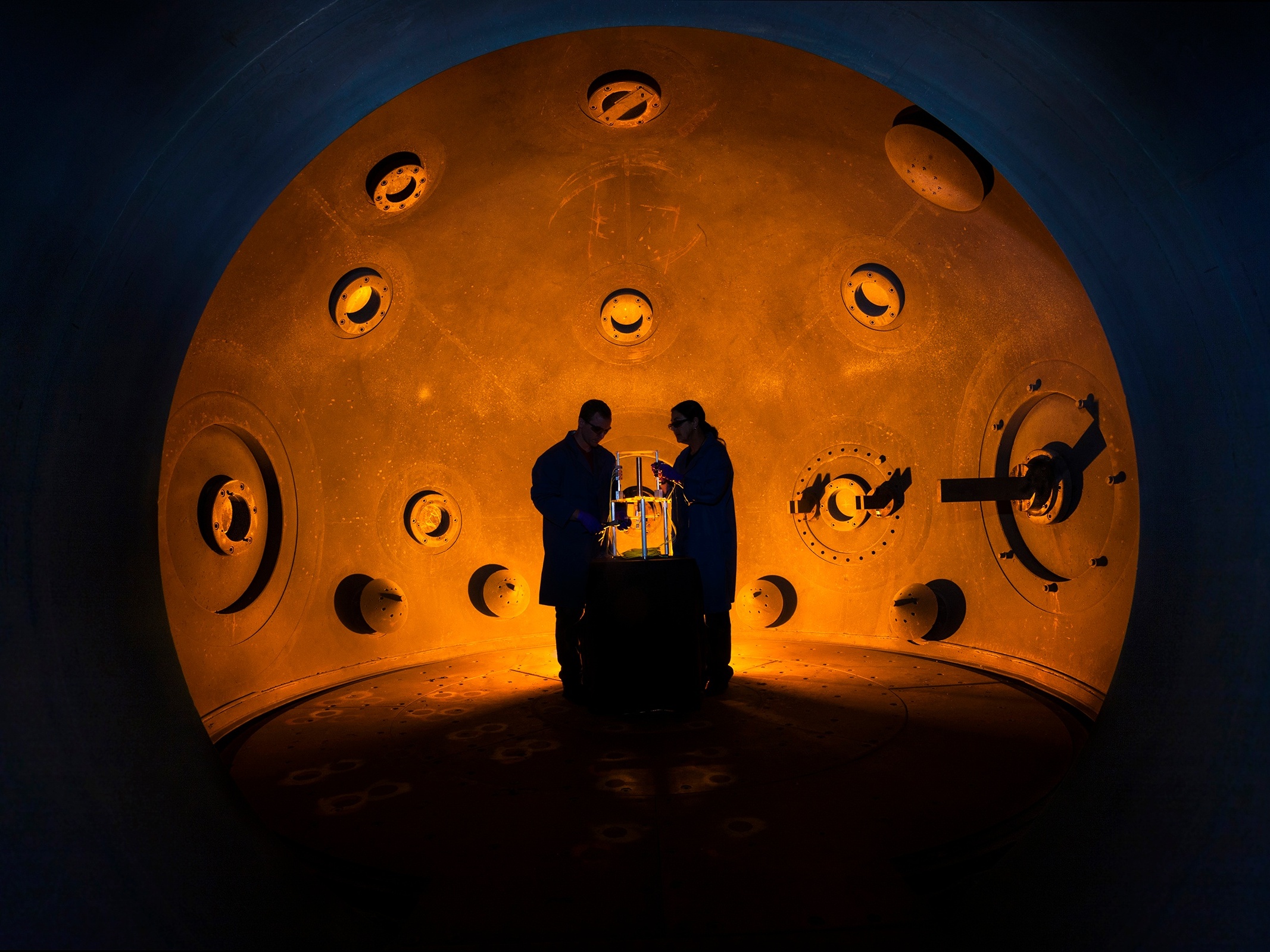 caption: Workers stand inside a special chamber at Lawrence Livermore National Laboratory. The chamber is used to test new conventional explosives used to detonate advanced nuclear weapons designs, and the data produced from such experiments is considered restricted.
