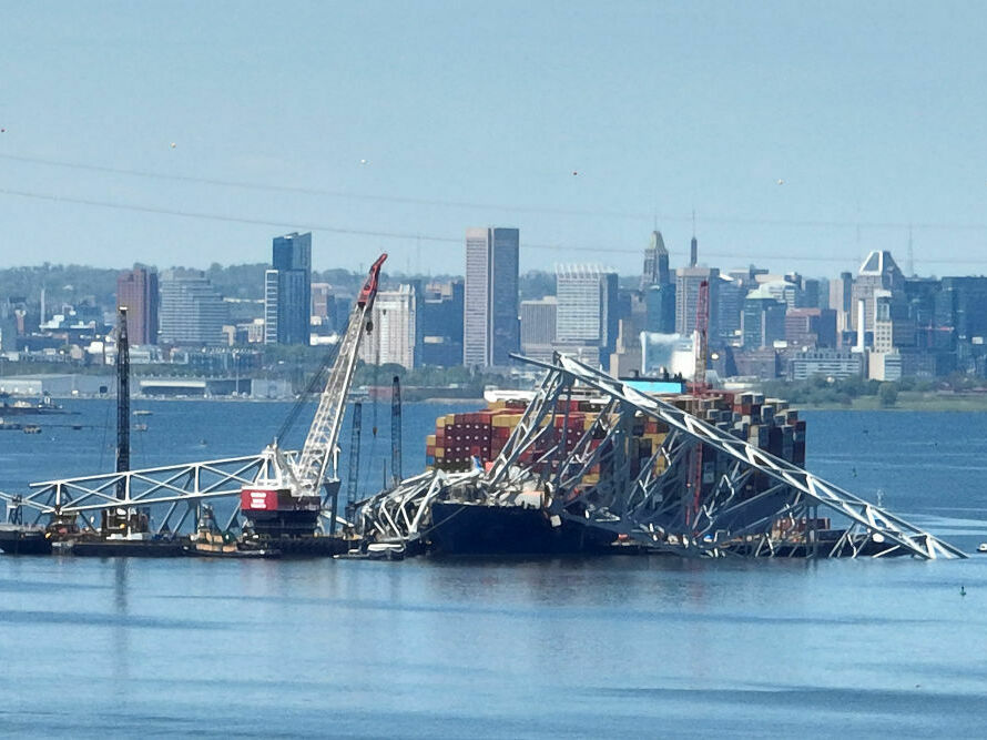 caption: Salvage crews in Baltimore continue to remove wreckage from the Dali on April 26, one month after the cargo ship smashed into the Francis Scott Key Bridge and caused it to collapse.