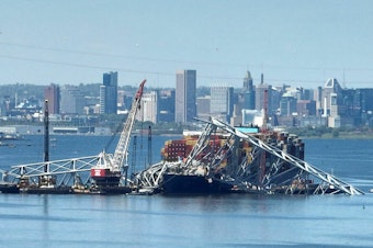 caption: Salvage crews in Baltimore continue to remove wreckage from the Dali on April 26, one month after the cargo ship smashed into the Francis Scott Key Bridge and caused it to collapse.