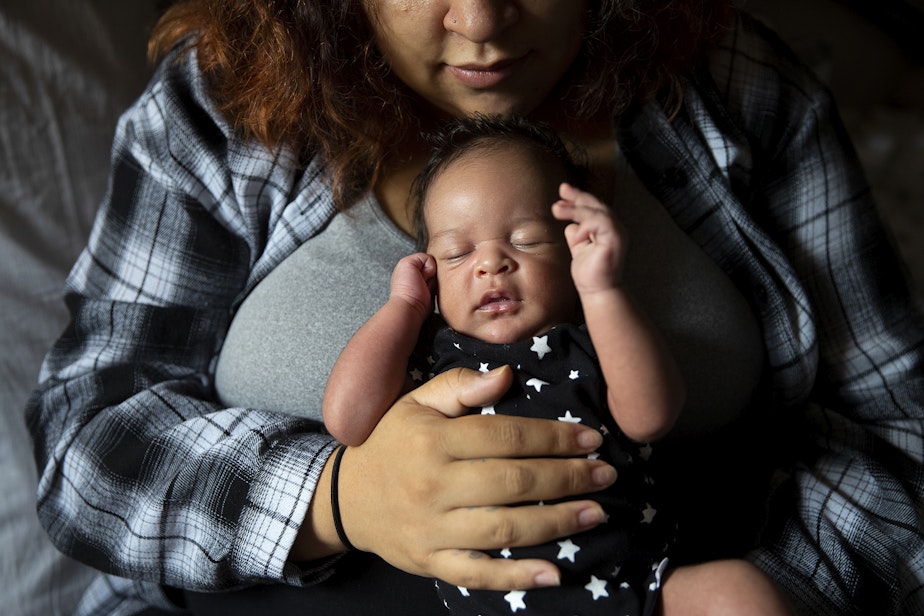 caption: Deita McChristian holds her son Alfred, born at the end of September, on Tuesday, October 17, 2023, at her apartment in Tacoma. 
