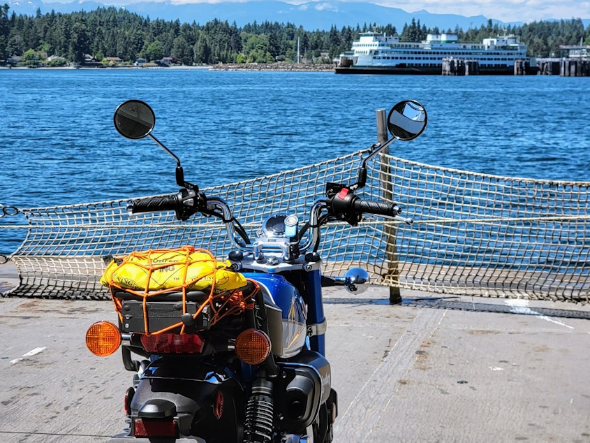 caption: A Honda motorcycle on the front of the ferry approaching Kingston terminal.