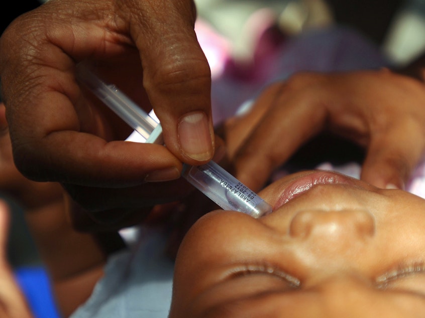 caption: A nurse vaccinates a baby against rotavirus, a deadly form of diarrhea.