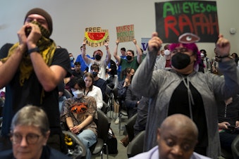 caption: Students cheer for a fellow student who spoke to the UW Board of Regent during public comment, imploring them to divest from Israel and to cut ties with Boeing, at the UW Board of Regents meeting on Thursday, May 9, 2024, on campus in Seattle. 