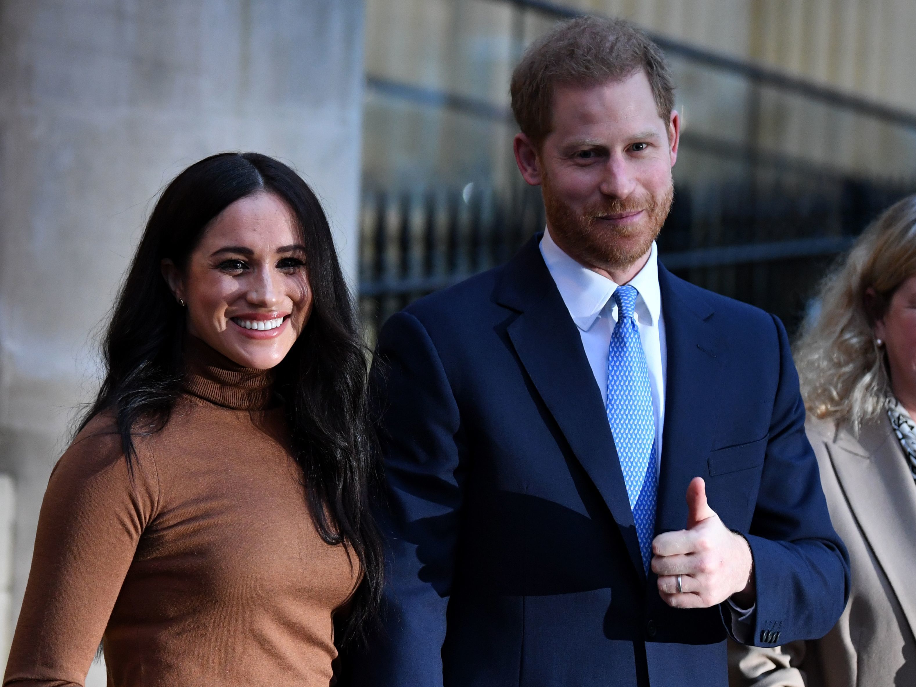 caption: Meghan and Prince Harry as they leave Canada House in London on Tuesday.