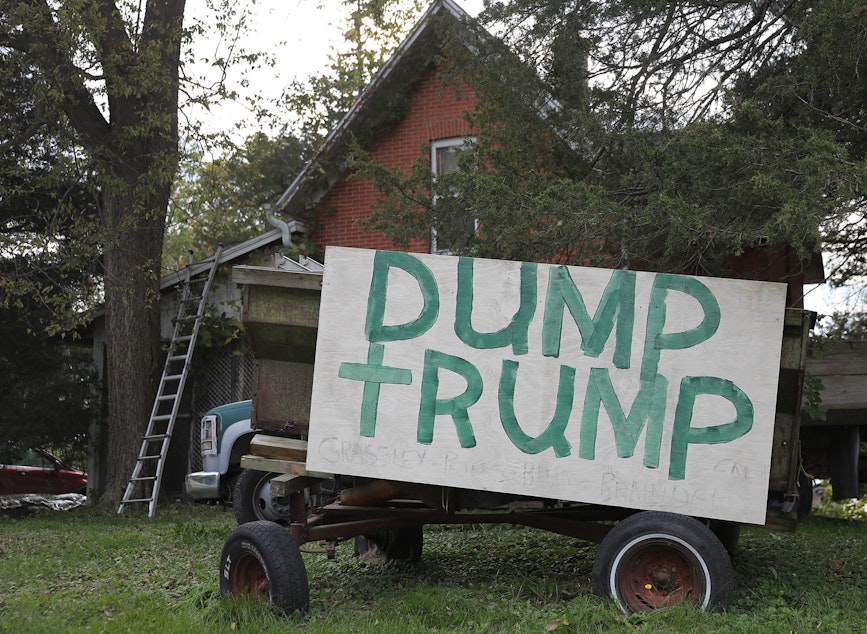 caption: A sign reading "Dump Trump" is seen on the front yard of a home on Oct. 13, 2019, in Iowa. (Joe Raedle/Getty Images)