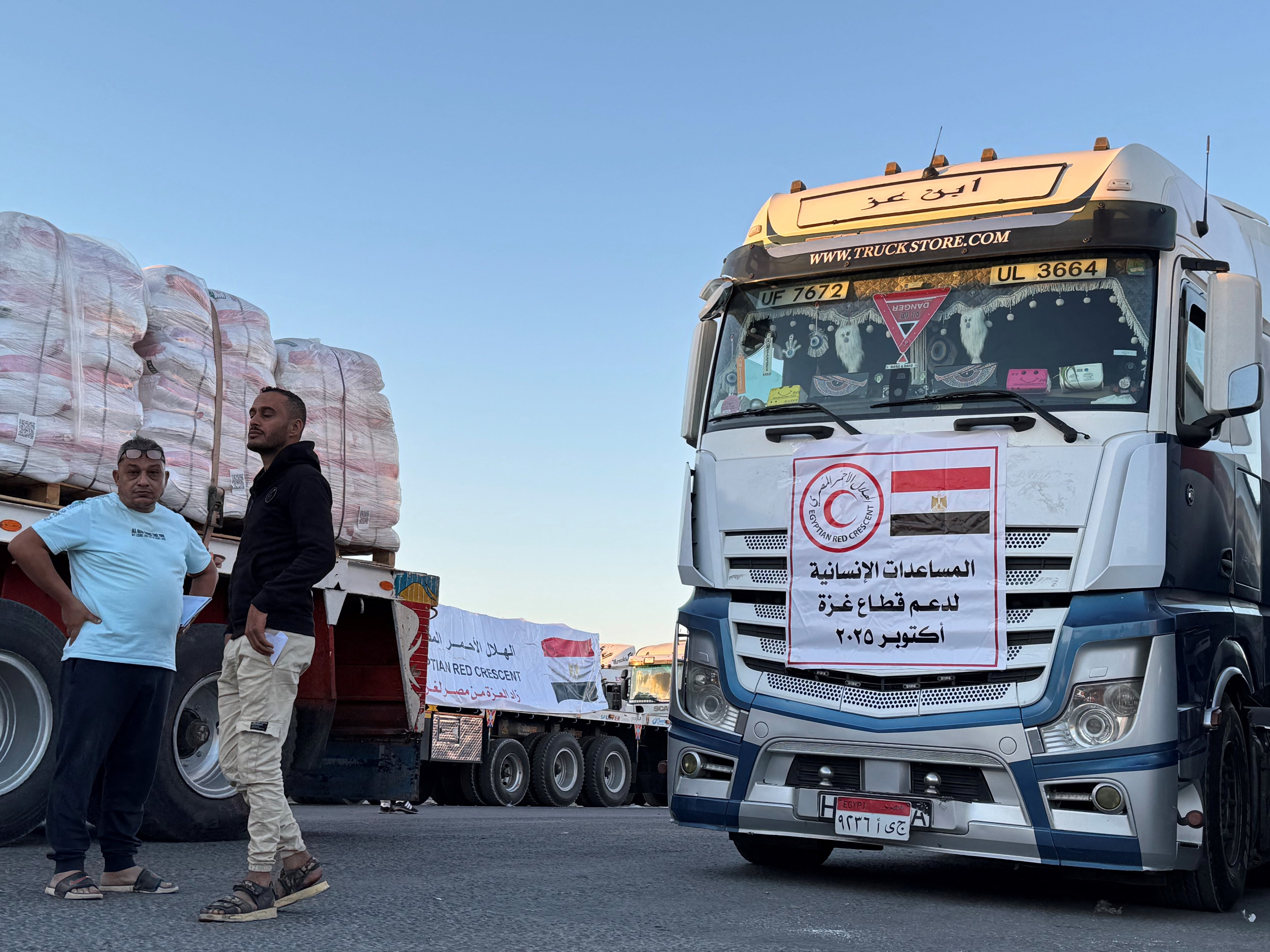 caption: Trucks loaded with humanitarian aid on the Egyptian side of the Rafah crossing wait to cross into the Gaza Strip early on Wednesday.