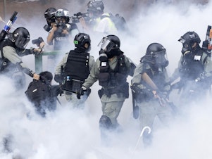 caption: Police in riot gear move through a cloud of smoke as they detain a protester, in November. Freedom House cited the willingness of people in Hong Kong to protest as encouraging.