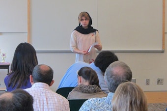 caption: David Reed’s daughter, Alia Reed, speaks in front a group during a speech contest. She gained confidence in public speaking through participating in the Toastmasters Gavel Club program.
