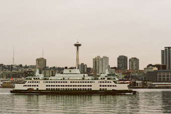 caption: A Washington State Ferry crosses in front of Seattle, in Elliott Bay, after crossing Puget Sound. 