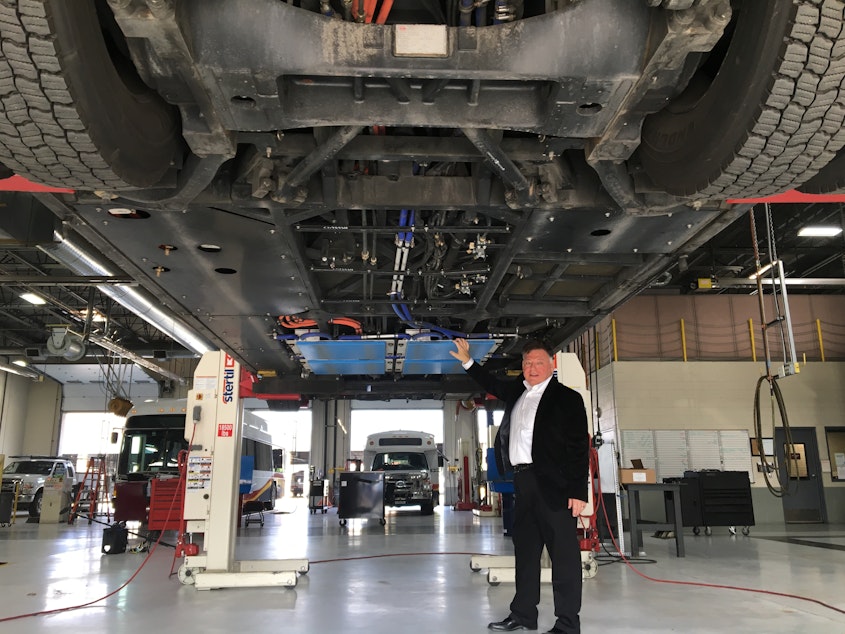caption: Andy Daga of Momentum Dynamics beneath a Link Transit bus in Wenatchee, Washington