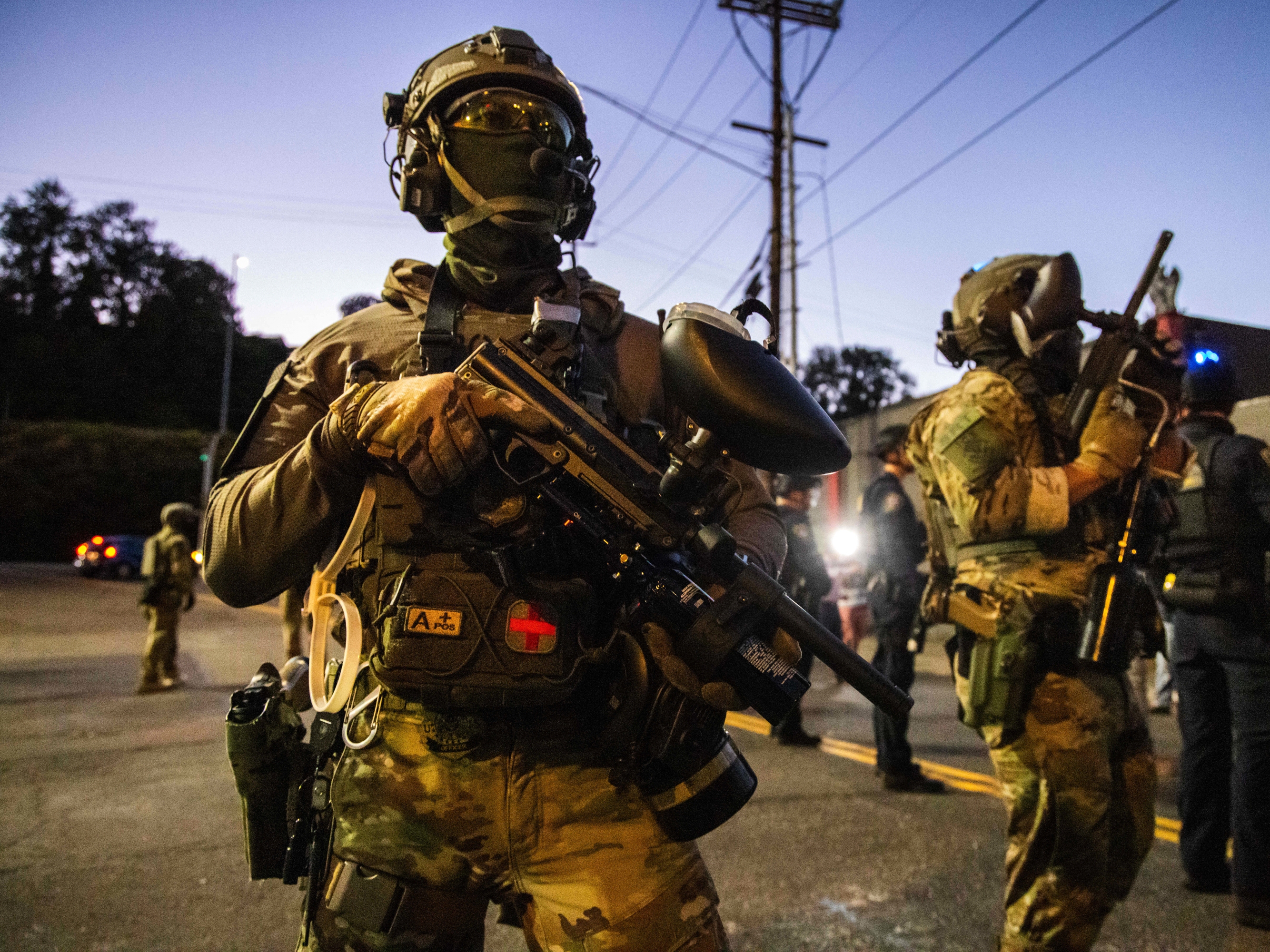 caption: Federal enforcement officers stand guard near a U.S. Immigration and Customs Enforcement facility in Portland, Ore., Monday, Oct. 6, 2025.