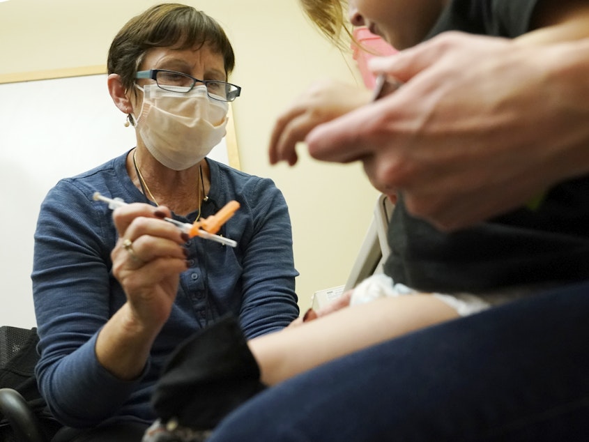 caption: A nurse at a University of Washington Medical Center clinic in Seattle gives a Pfizer COVID-19 vaccine shot to a 20-month-old child on June 21.