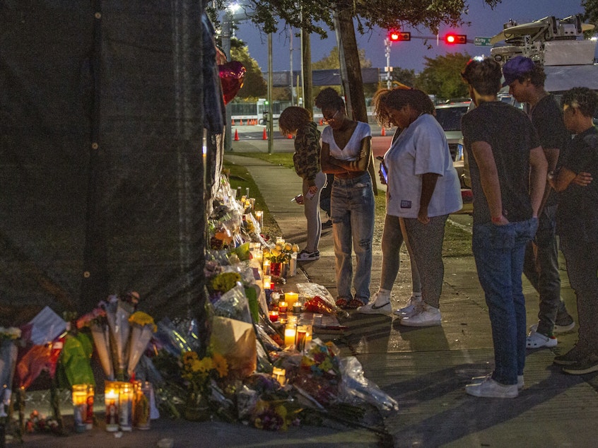 caption: People attend a makeshift memorial on Sunday at the NRG Park grounds where eight people died in a crowd surge at the Astroworld Festival in Houston.