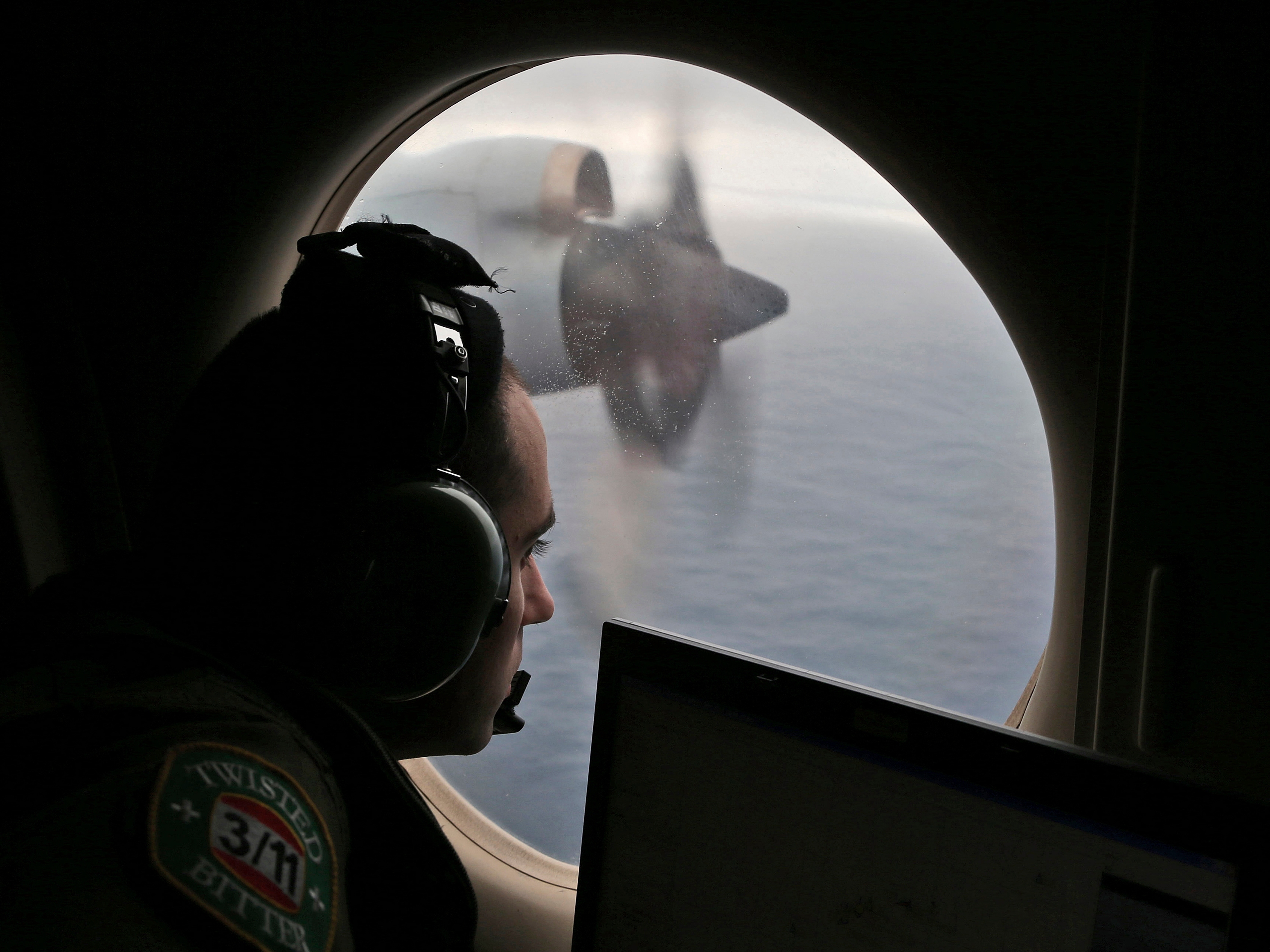 caption: FILE - Flight officer Rayan Gharazeddine scans the water in the southern Indian Ocean off Australia from a Royal Australian Air Force AP-3C Orion during a search for the missing Malaysia Airlines Flight MH370 on March 22, 2014.