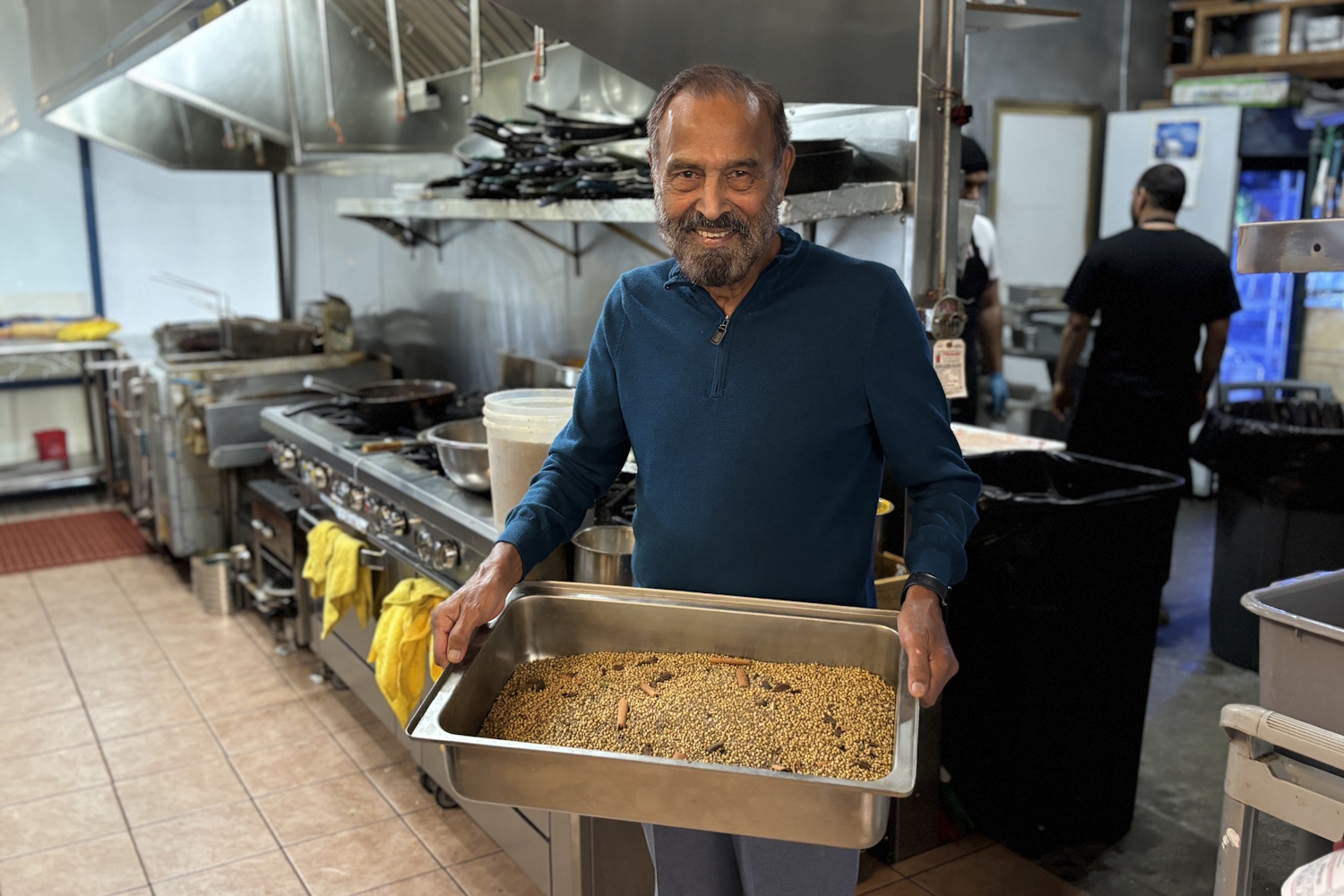 caption: Kabal Gill holds out a tray of spices at East India Grill in Federal Way.