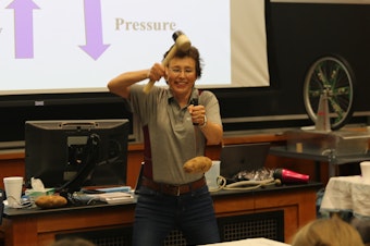 caption: During a Summer Science Safari demonstration at Texas A&M University in 2022, Dr. Tatiana hits a knife down to make the potato go up. It's not magic, it's inertia.