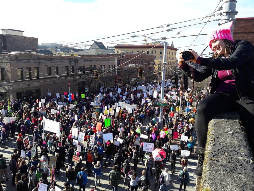 caption: Elle Christensen watches 2017's women's march in Seattle from a perch at Seventh and Jackson.