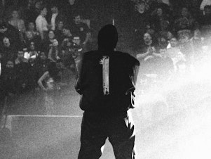 caption: Inside Long Island's UBS Arena on Feb. 9, Ye commands the crowd at a massive listening event for <em>Vultures 1</em>. His new collab with Ty Dolla $ign is now a No. 1. album.