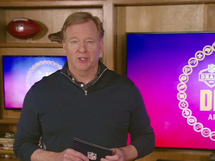 caption: NFL Commissioner Roger Goodell, seen during last week's league draft, is cutting his salary, along with those of league employees who make over $100,000.