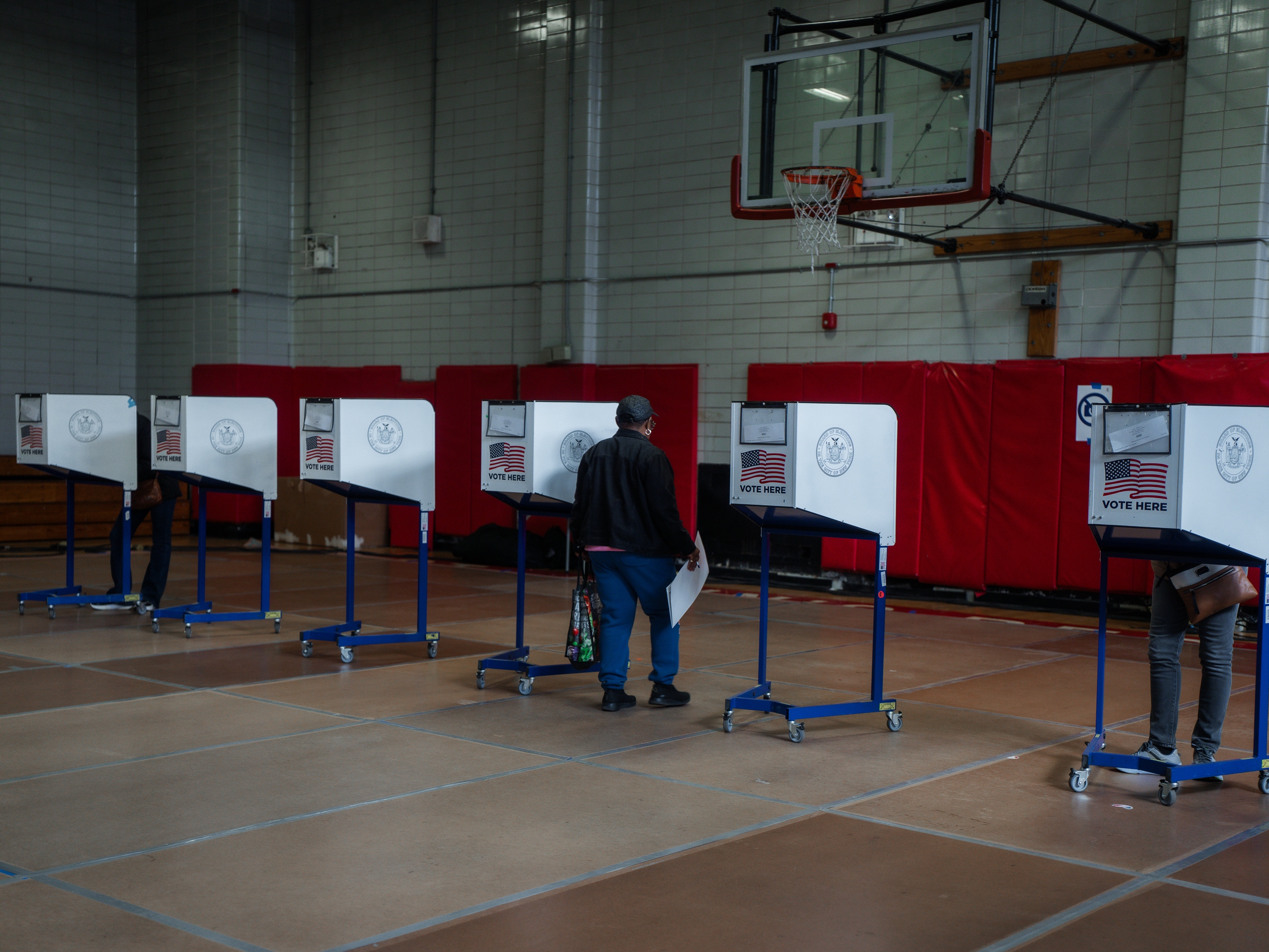 caption: A voter carries a ballot during early voting for New York City's mayoral election on Oct. 25, 2025.